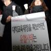 -한국 대학생 대표자 농성단 학생들이 이명박 정부의 교육 정책을 비판하는 팻말을 들고 있다.