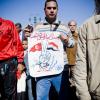 -2월 18일 타흐리르 광장에서 한 민주화 시위대가 이집트의 튀니지의 국기가 그려져 있는 배너를 들고 행진하고 있다. 배너에는 "민중들의 목소리보다 더 큰 소리는 없다" 라고 적혀져 있다.