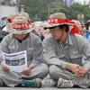 -유성기업 노동자들이 연대 파업을 호소하는 <레프트21> 호외를 유심히 읽고 있다.