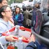 -9일 오전 부산 남포동 BIFF 광장에서 ‘5차 희망의 버스’ 참가자들이 아침 식사를 하던 중 경찰들이 참가자들을 위협하자 한진중공업 가족대책위가 준비한 사과를 들어보이며 경찰에게 항의하고 있다.