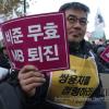 -10일 오후 대한문에서 열린  ‘Occupy Seoul 2차 국제 공동행동’에서 김정우 금속노조 쌍용차지부 지부장이 "비준무효, MB퇴진" 적힌 팻말을 들고 있다.