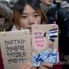 - 10일 오후 대한문에서 열린 ‘Occupy Seoul 2차 국제 공동행동’에서 한 참가자가 제주도 해군 기지 건설에 반대하는 팻말을 들고 있다.
