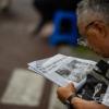 -7월 15일 오후 윤석열 퇴진 전국 집중 집회에서 한 참가자가 <노동자 연대> 신문을 정독하고 있다.