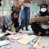 -4월 6일 오후 서울 광화문 D타워 앞에서 열린 ‘가자지구 전쟁 6개월 4.6 집중 행동의 날’ 집회에서 참가자들이 팻말을 직접 만들고 있다.